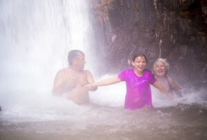 A family plays in at the base of Deer Creek Falls.