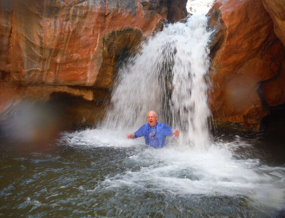 Phil splashing in a waterfall in Grand Canyon.