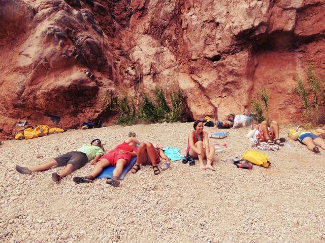 Grand Canyon Whitewater rafters relax at the base of Deer Creek Waterfall.