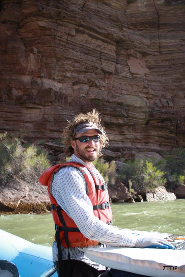Grand Canyon Whitewater guide Dan Hall drives a motor boat through the Canyon.