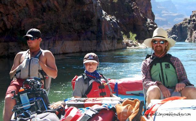 Grand Canyon Whitewater raft guide teaches a passenger how to drive the motorized raft.