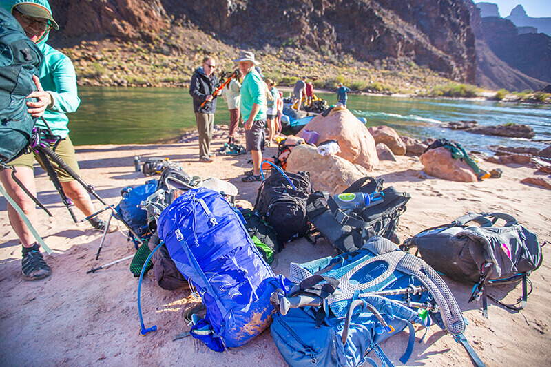 People unloading backpacks at Pipe Creek along the Colorado River.