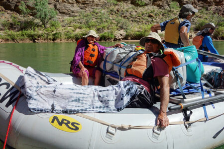 Man with sarong draped over legs.