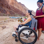 A woman braiding the hair of a person in a wheelchair.