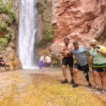 A man with a prosthetic is helped at Deer Creek falls.
